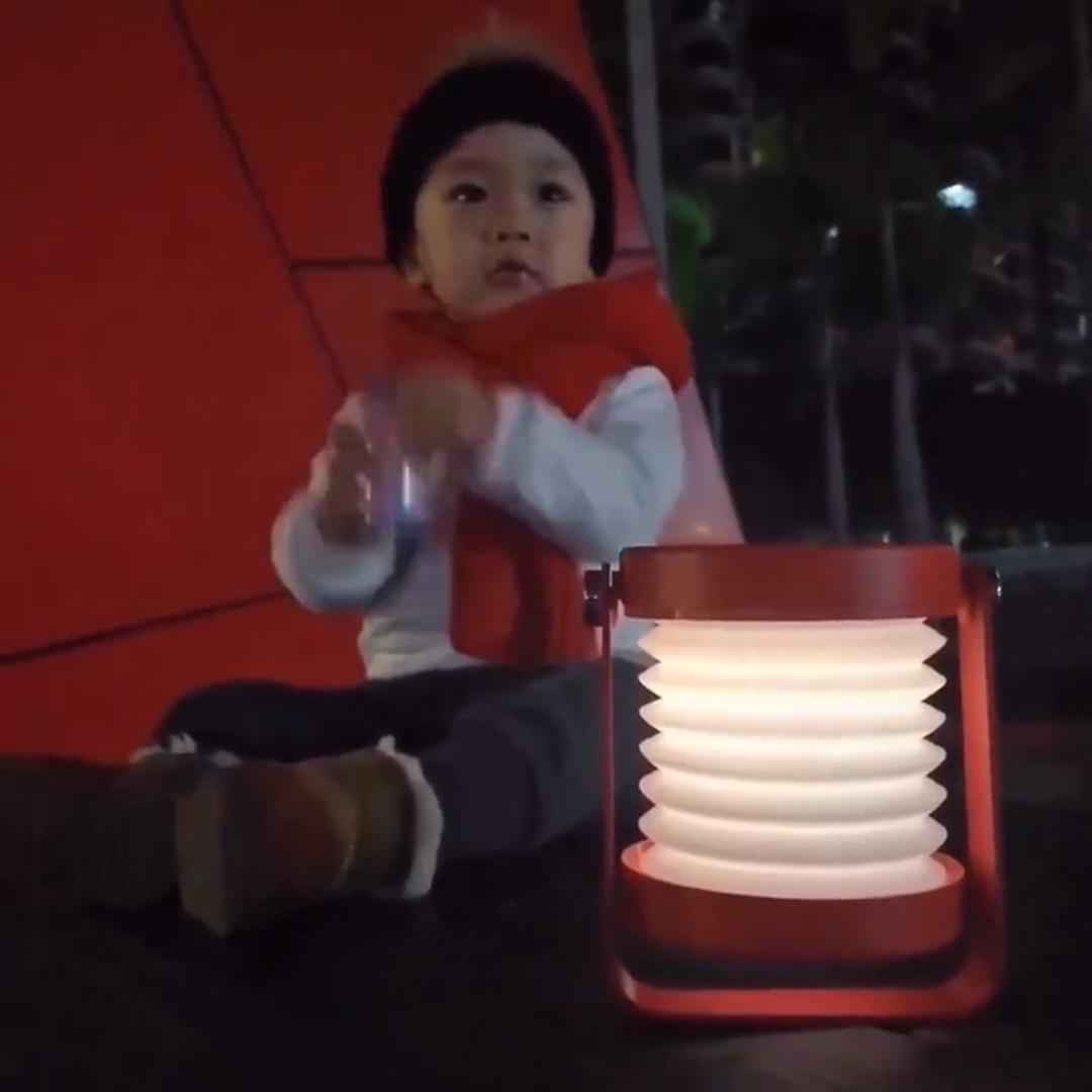 LED lantern lamp expanded and glowing on nightstand